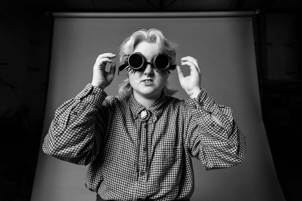 Studio portrait of college student wearing steampunk glasses