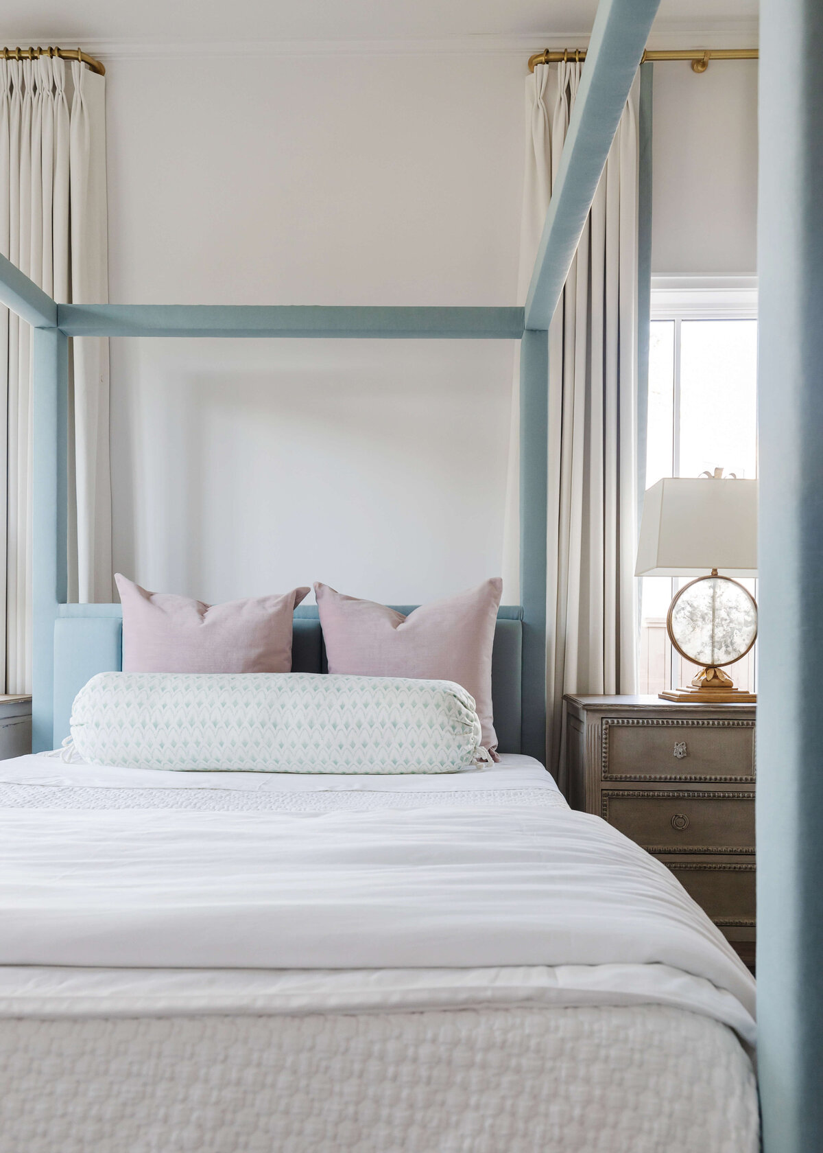 oyster creek studios memorial new build blue canopy bed with pink pillows and white bedspread in bedroom