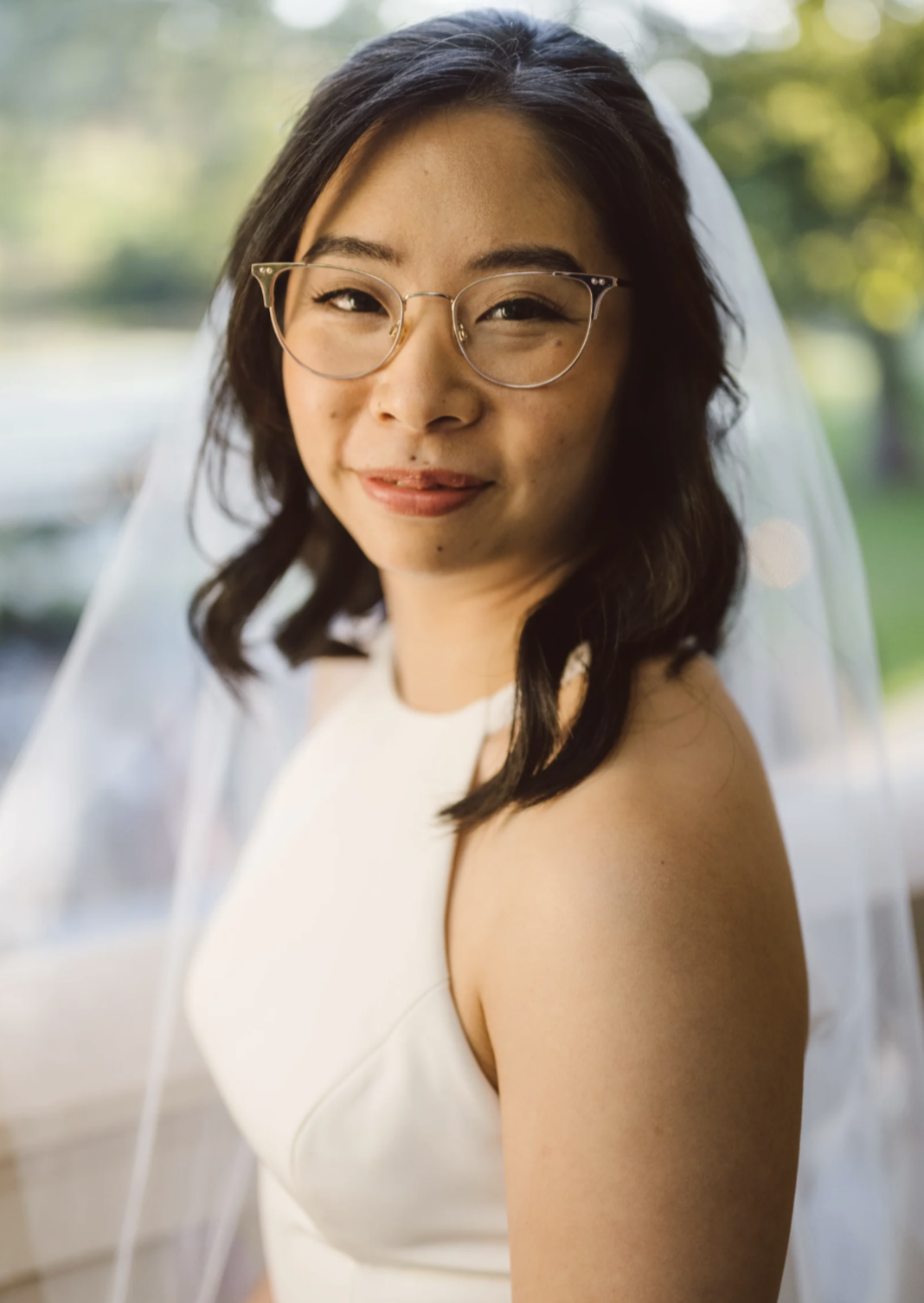 Bride in glasses posing outside Airlie Warrenton Virginia Wedding
