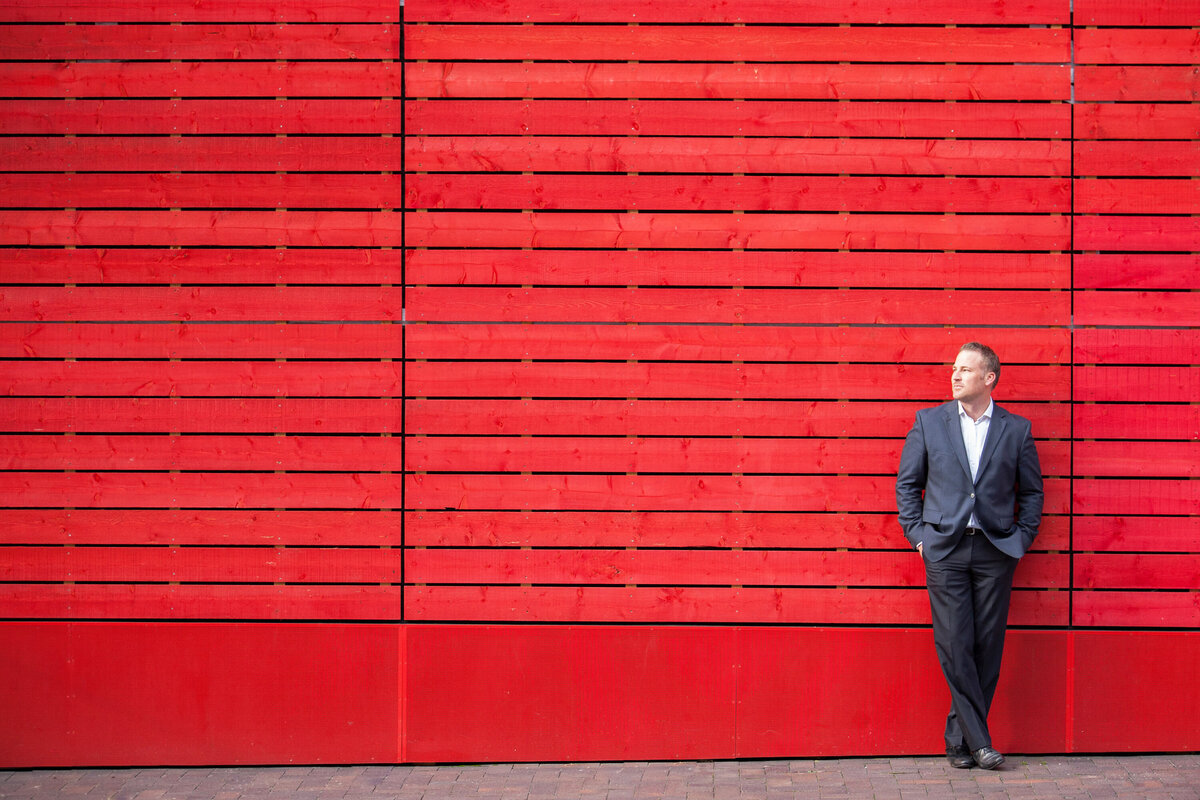 Man leaning against red wall