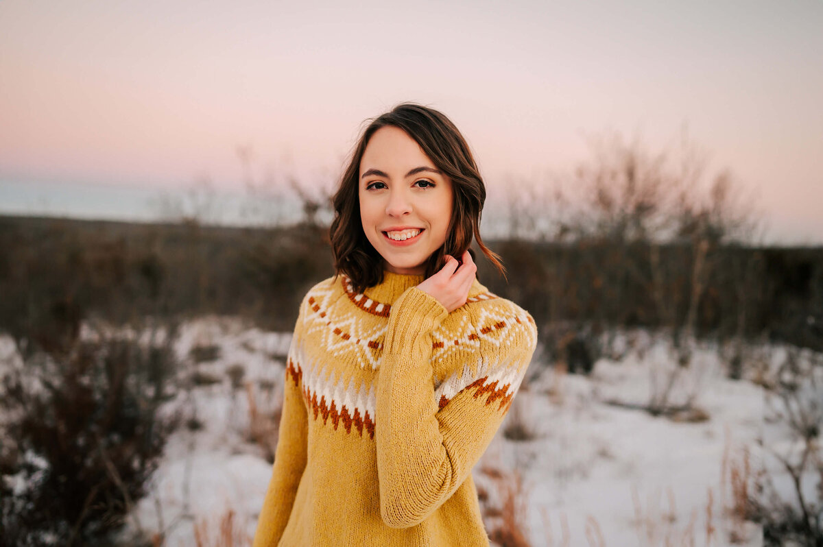 girl holding hair outdoors at sunset in the sun during Springfield MO senior photography