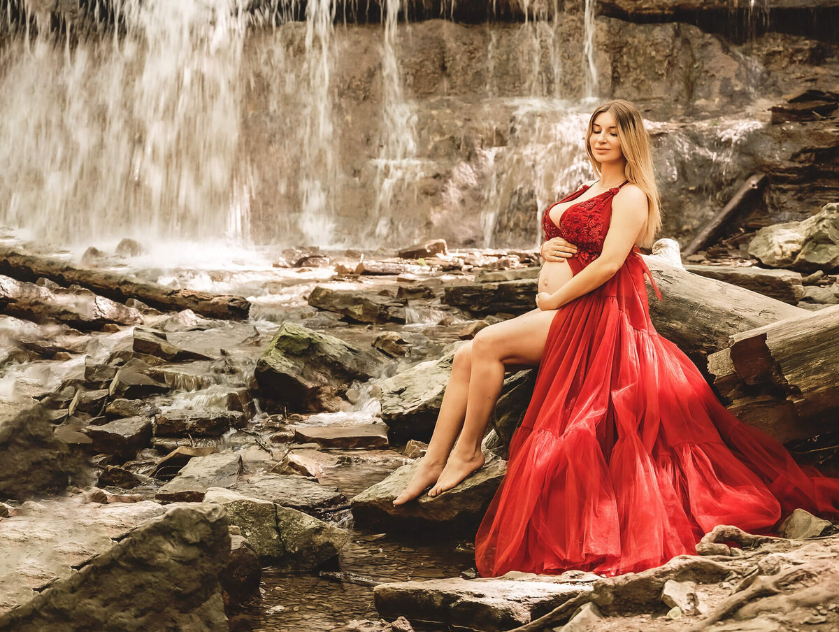 Maternity Photo shoot in the Greater Toronto area at Sherman Falls in a red gown in front of the falls, by Tamara Danielle.