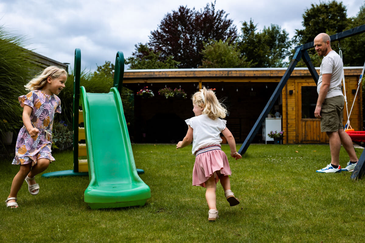 vader en dochters spelen in achtertuin