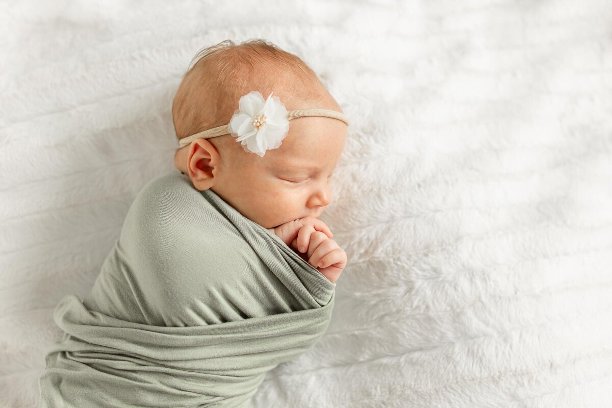 a newborn baby sleeping in a swaddle