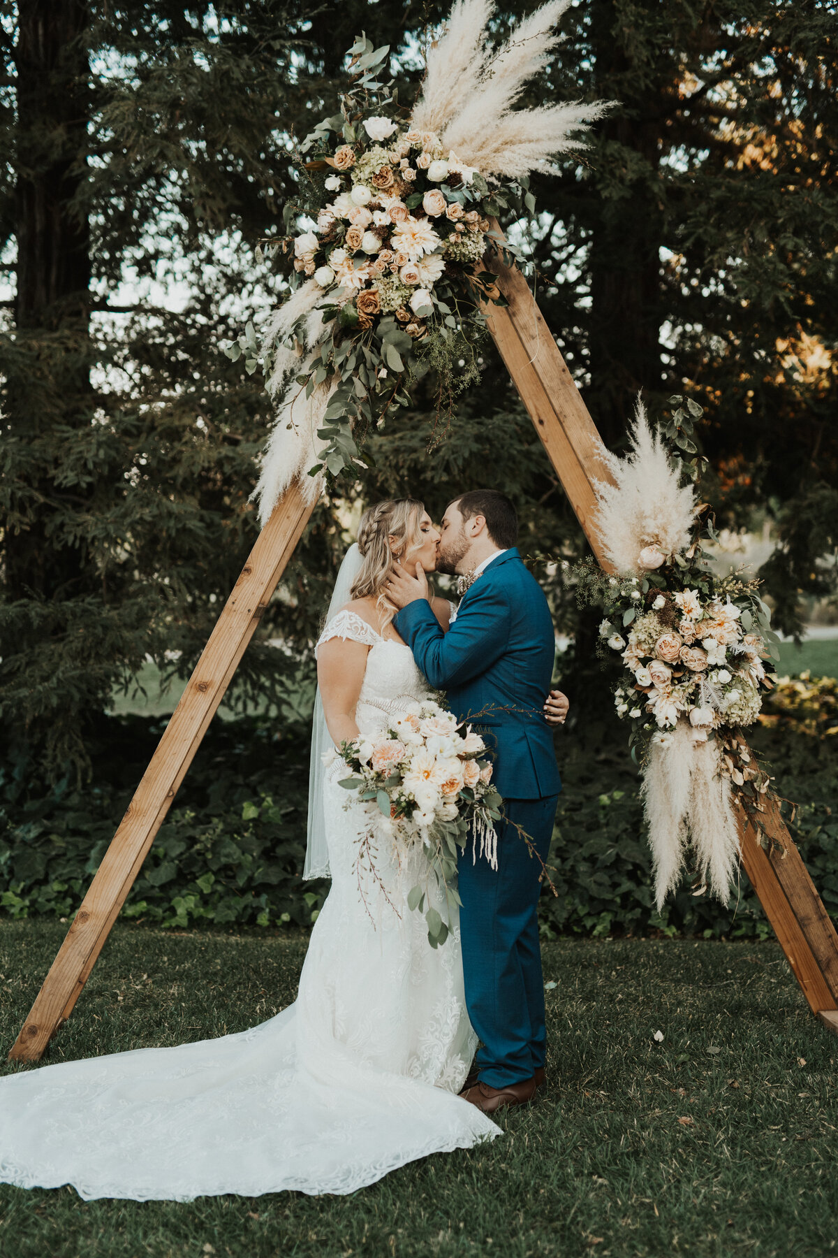man and woman kissing under a wood arch