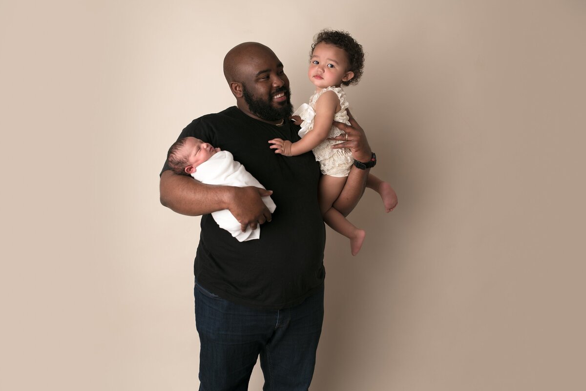 father holding two daughters