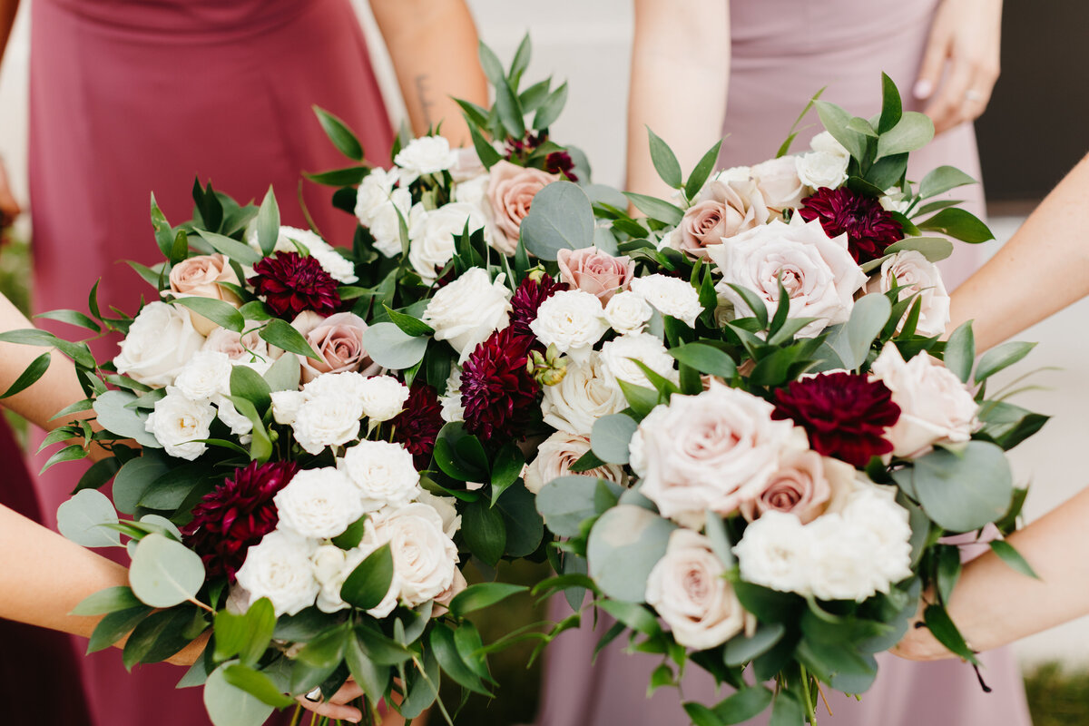 Close up image of wedding bouquets with white and red flowers and greenery