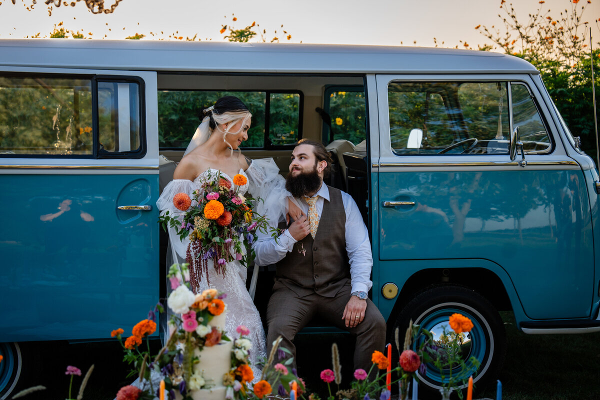 photo of a couple on their wedding day vintage inspired wedding decor bride and groom with a vw bus during sunset at 1886 Farmhouse in Boone Iowa near Des Moines Iowa