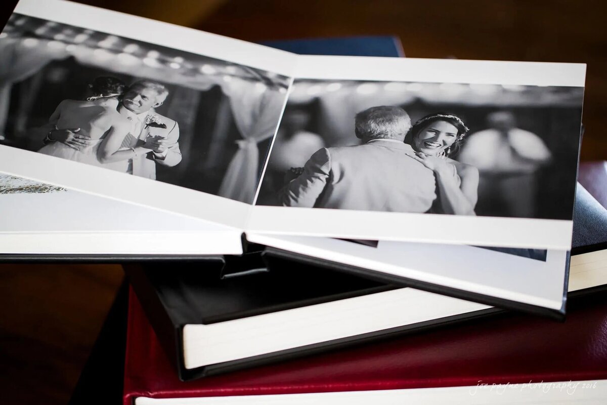 An open wedding album on top of two closed books