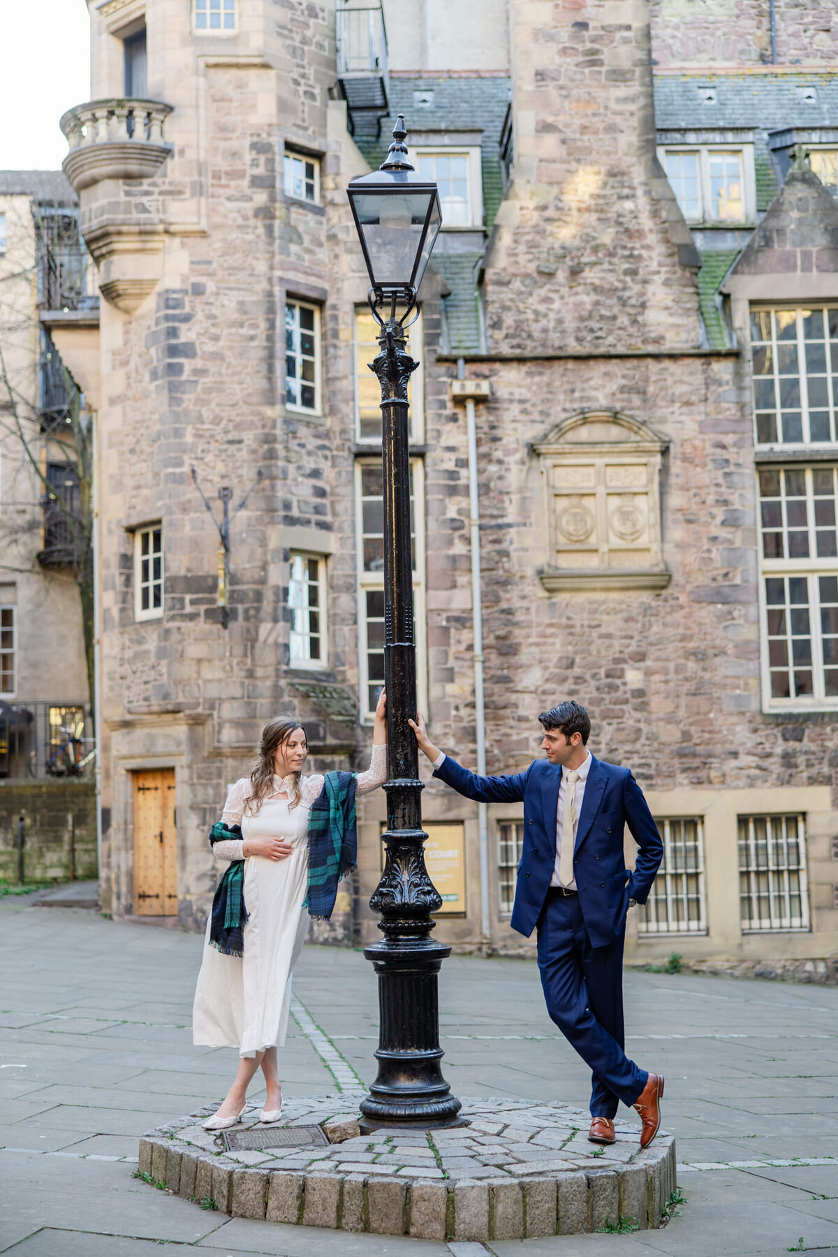 bride and groom leaning on historic light pole