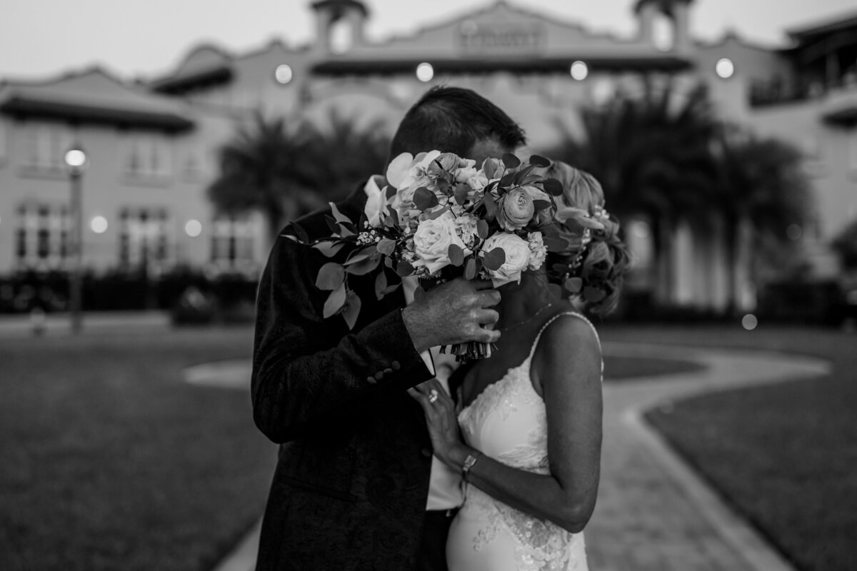 bride and groom kissing behind brides bouquet at fenway hotel in dunedin florida