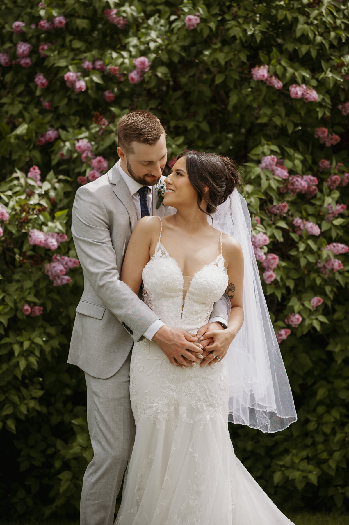 bride and groom in front of flowers on wedding day