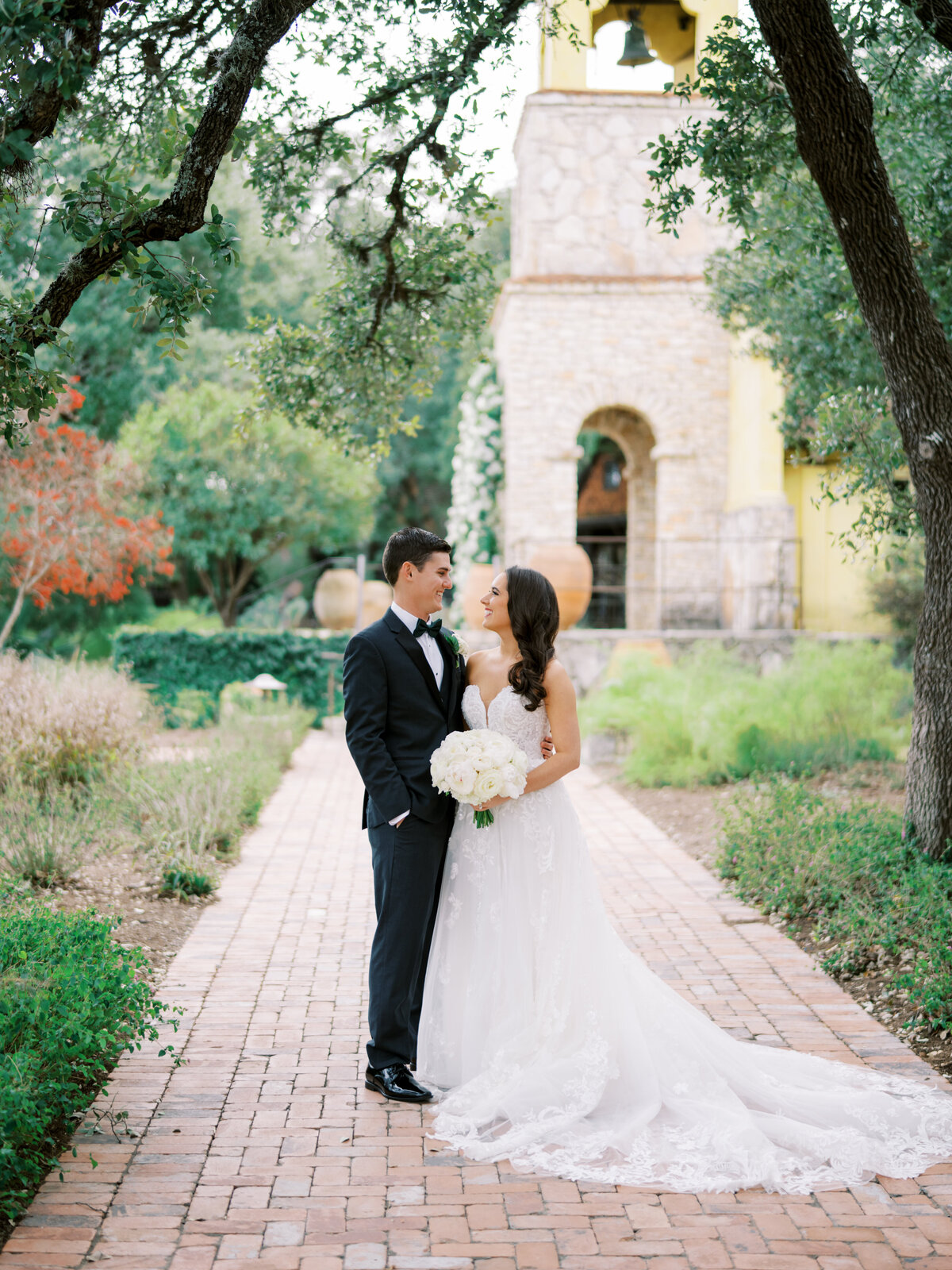 A married couple poses together next to Ian's Chapel at Camp Lucy in Dripping Springs