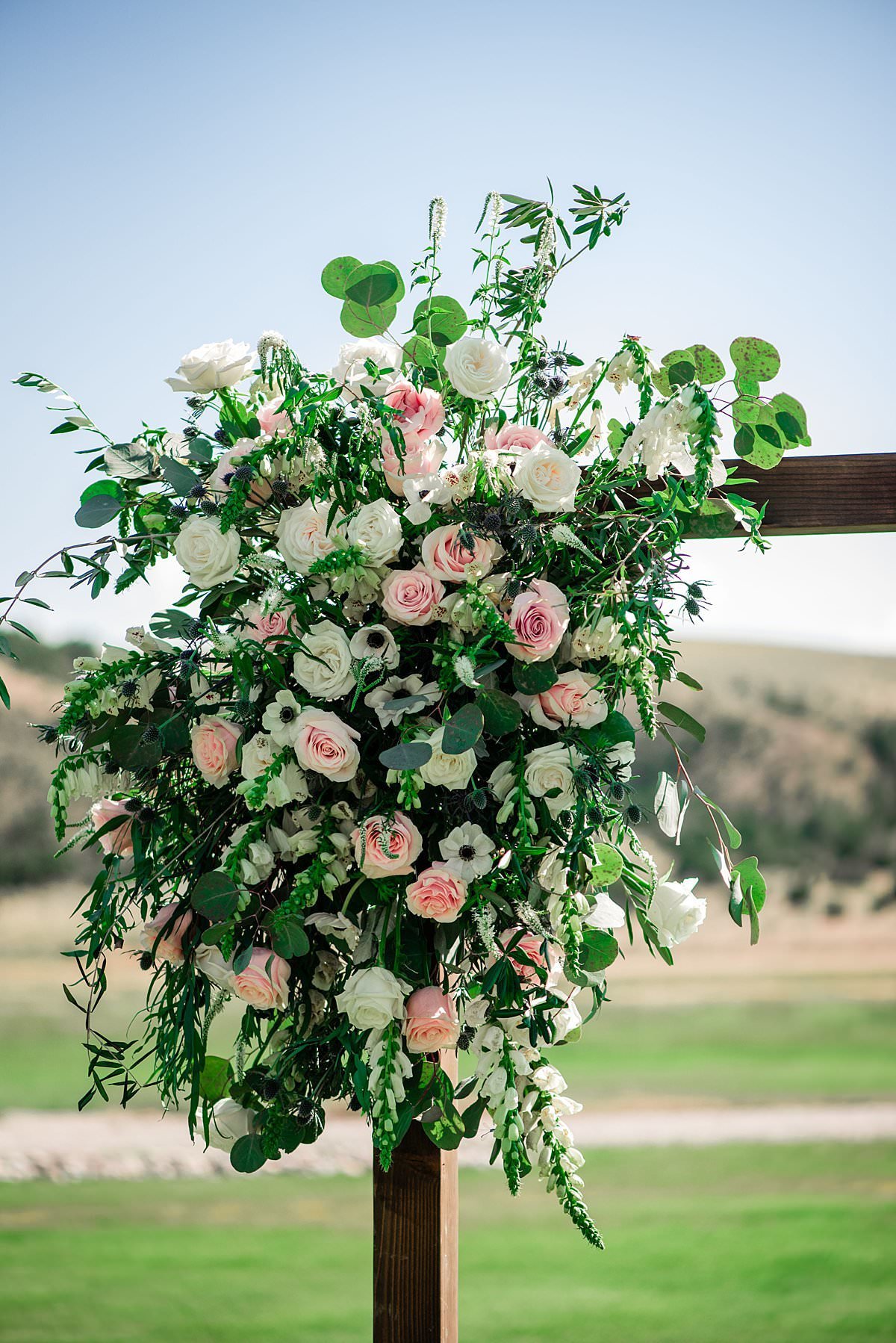 Large corner piece arbor flower instillation with anemones, roses, snapdragons  and greenery