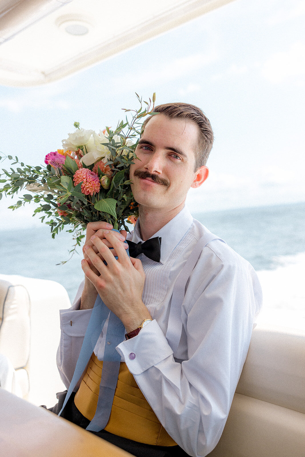 Groom holding bride's wedding bouquet
