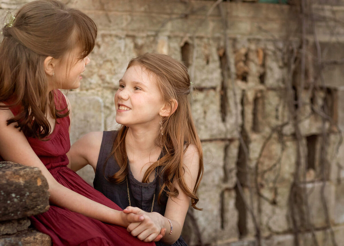 family photos of two sisters in NJ park looking at each other