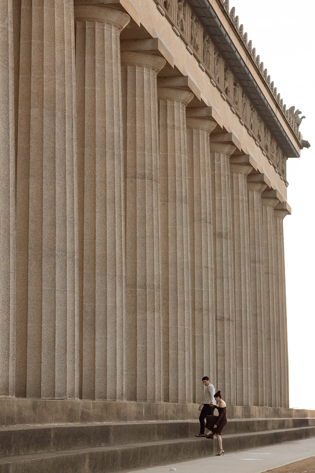 Man leads woman up the Parthenon steps in order to propose to her. 
