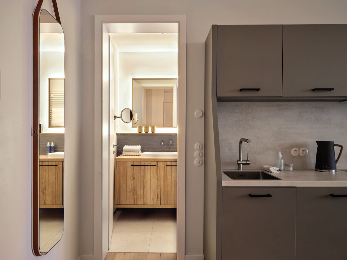 Blick auf die Küchenzeile sowie auf das Badezimmer des Couple Living Apartments.