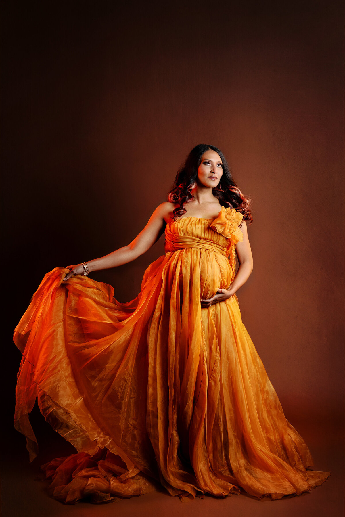 st-louis-maternity-photographer-pregnant-mom-in-orange-tulle-gown-and-orange-light-with-dress-movement