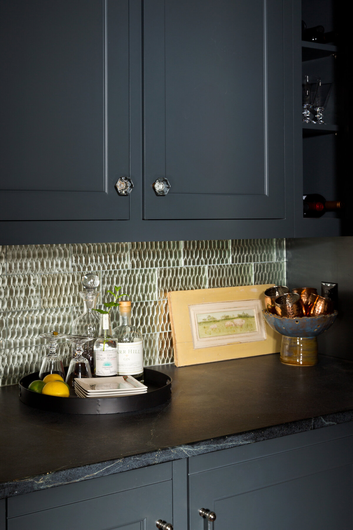 dark blue cabinets and bar with accent backsplash