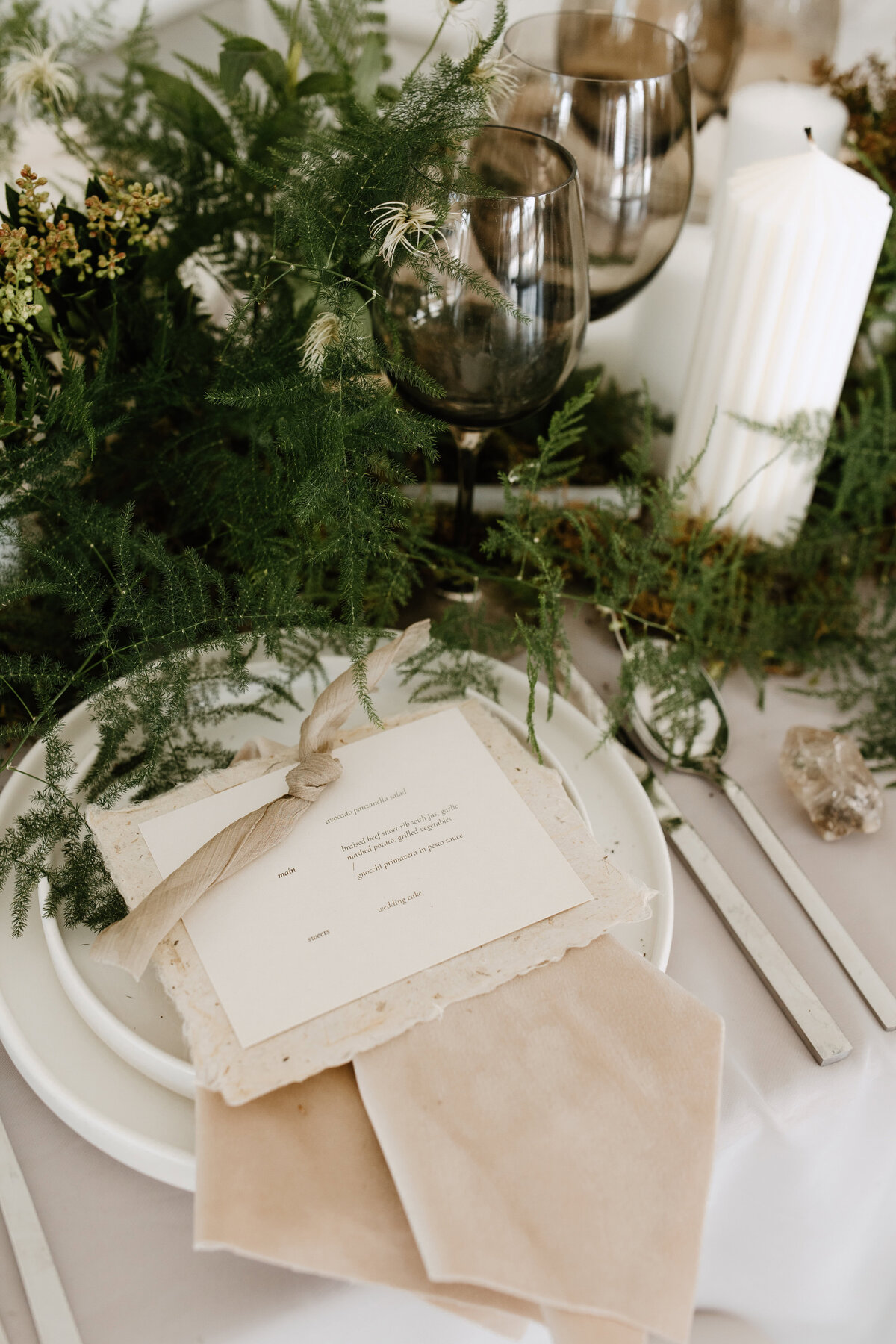 Detail shots of the invitation and tableware for the garden themed wedding reception