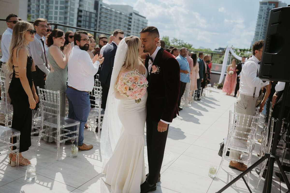 couple kissing as the exit rooftop ceremony in yeg