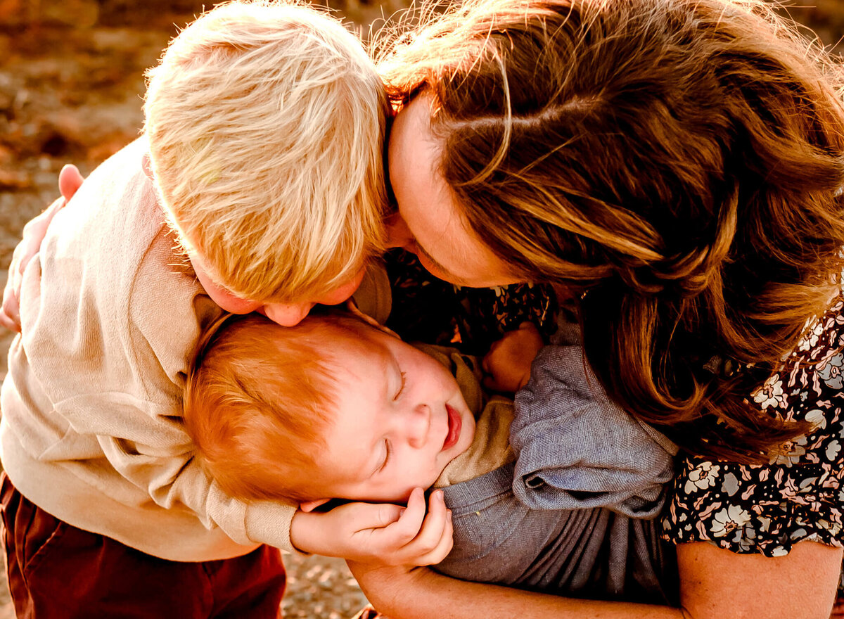 mom and two sons huddling close for family photography session in Arizona winter