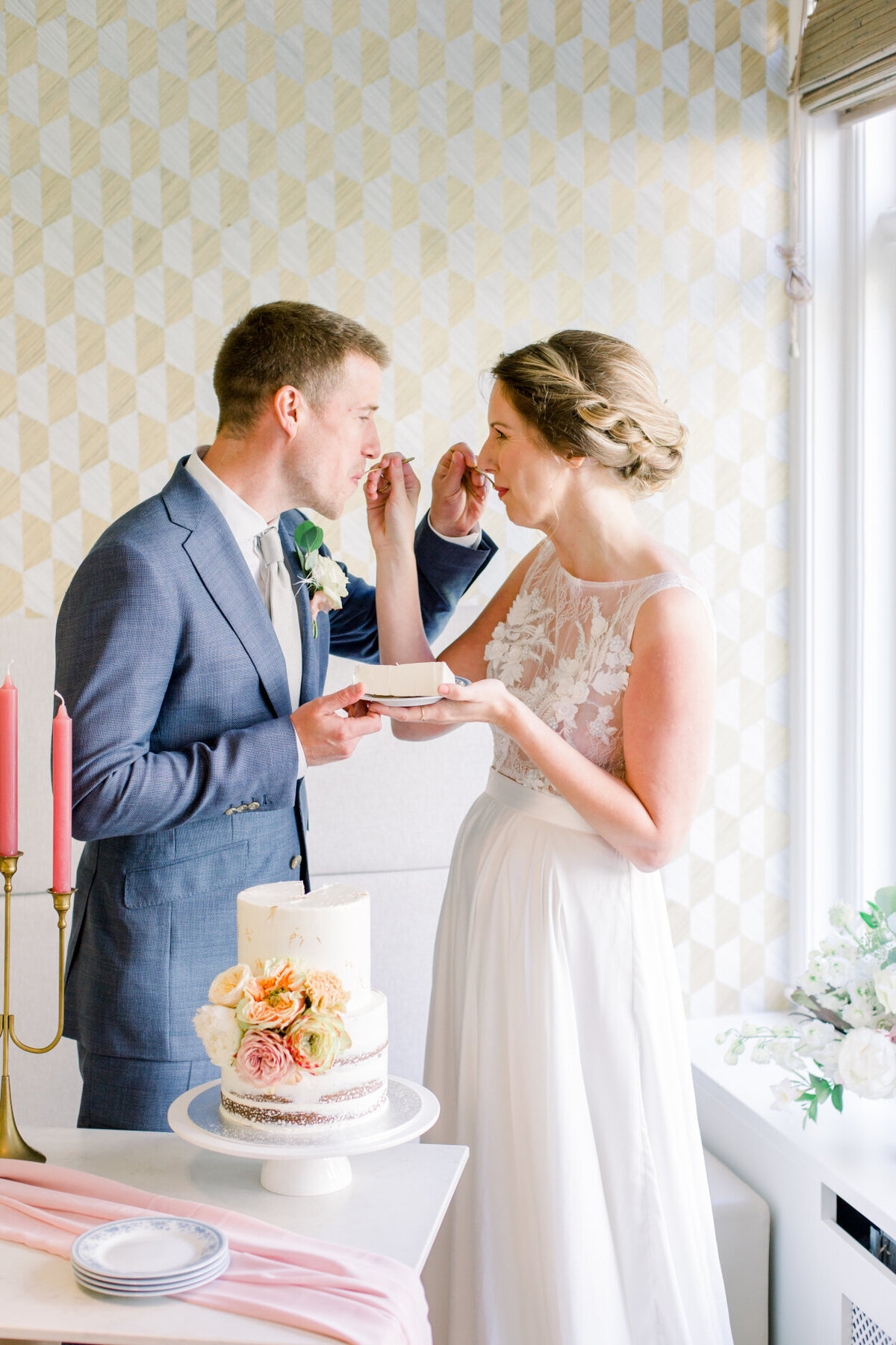Bride and groom take the first bite of their small wedding cake for an intimate wedding photoshoot at the Tassenmuseum organized by Lovely & Planned