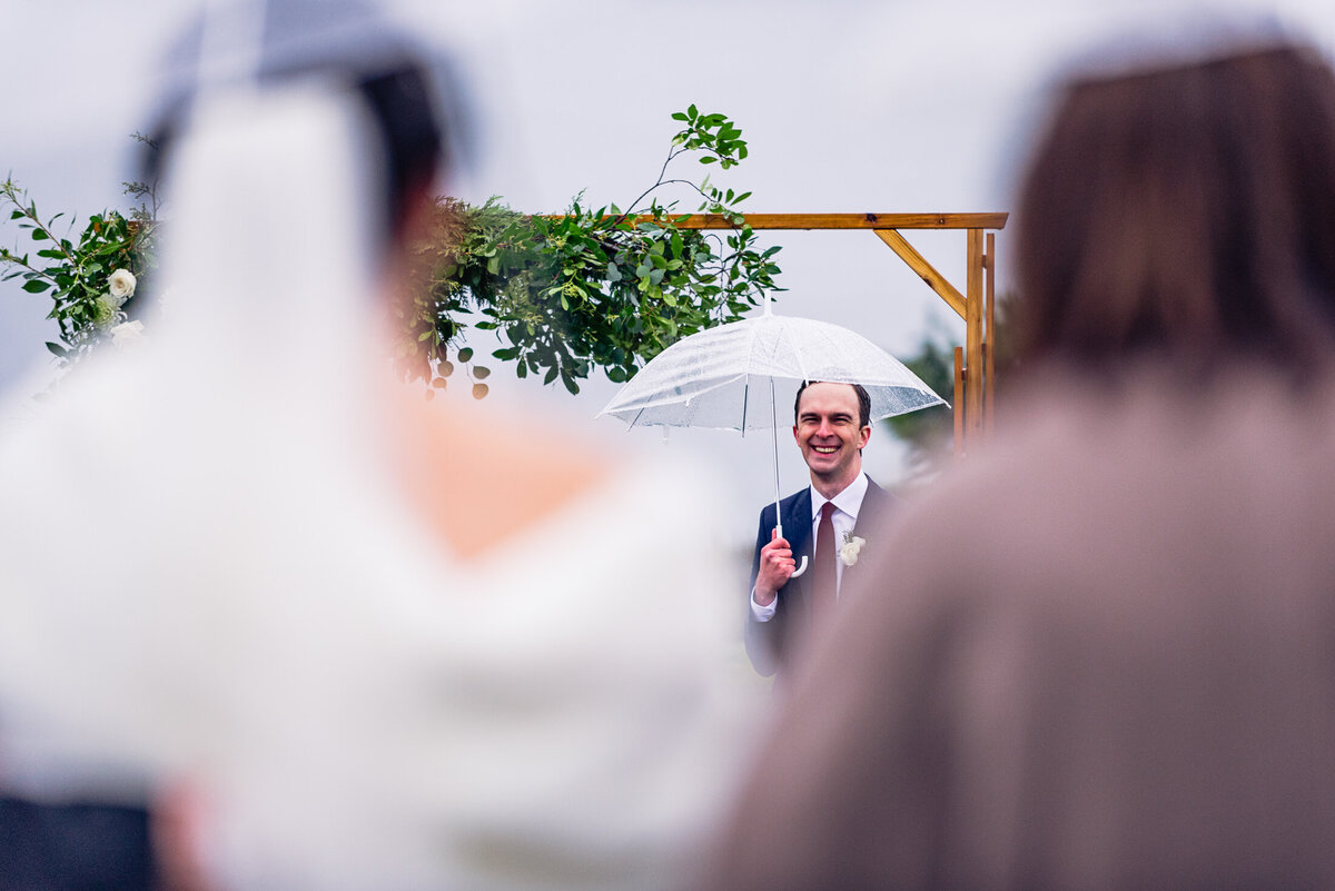 Grooms face with bride coming down the aisle