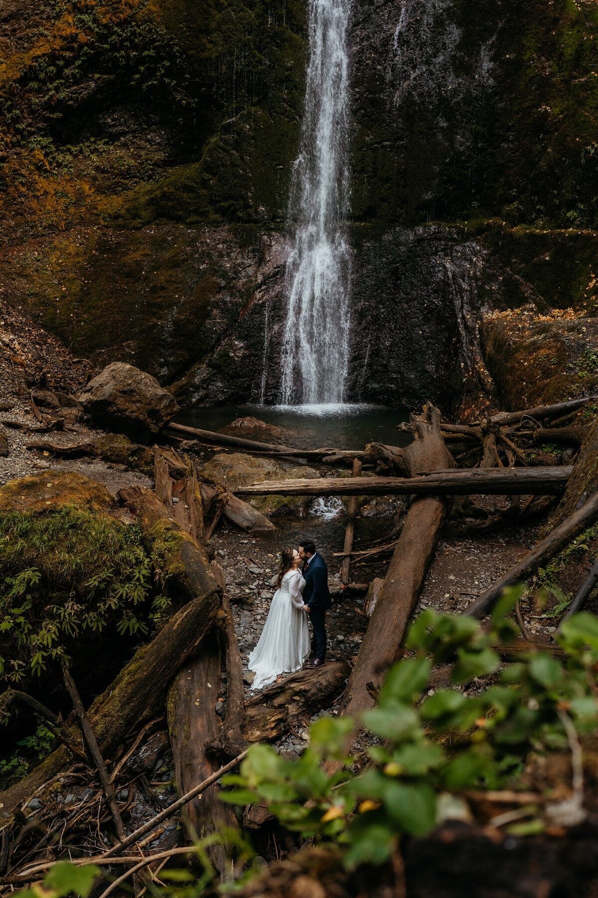 Bride & groom kissing under Marymere Falls after their elopement in Olympic National Park!