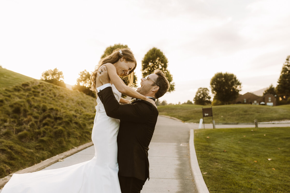 Groom lifting bride after ceremony