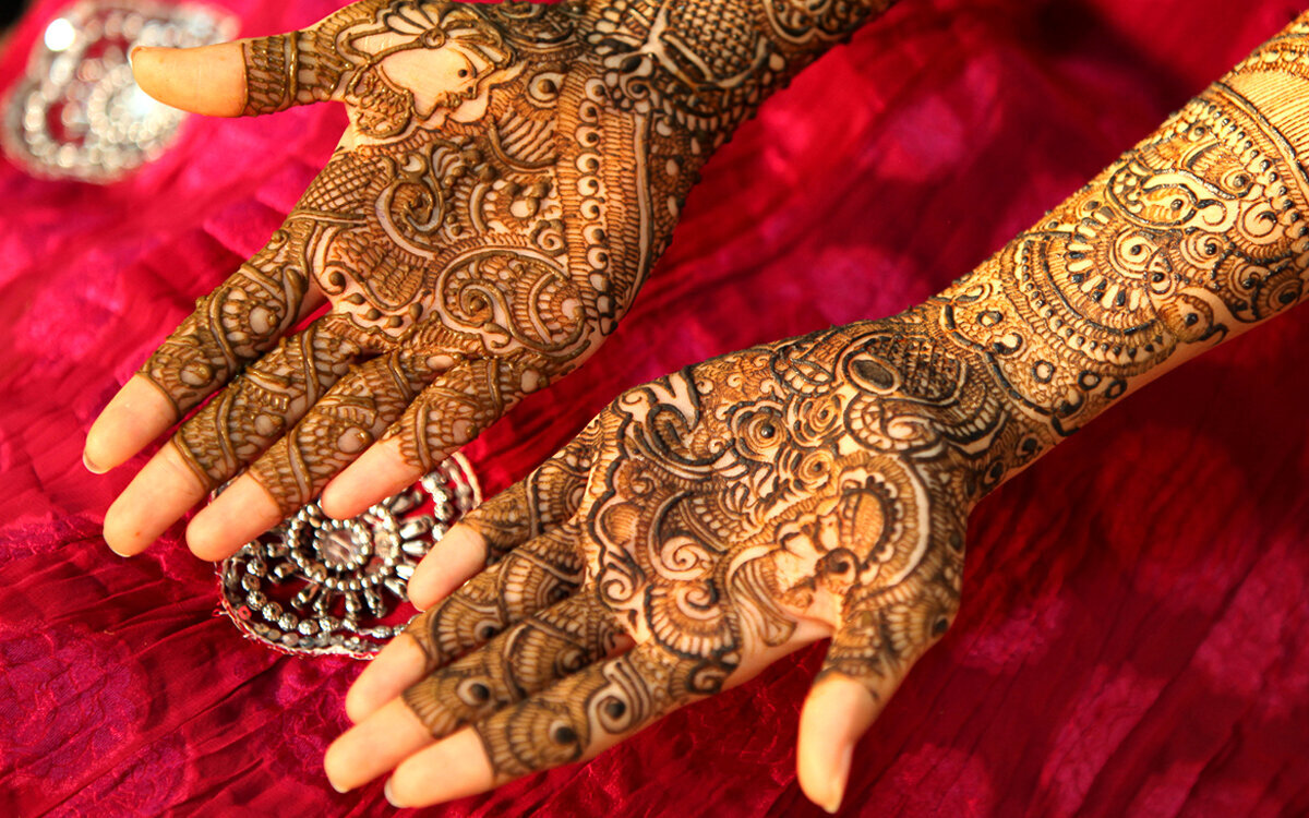 Bride’s hands adorned with intricate henna designs, showcasing traditional wedding artistry and cultural elegance