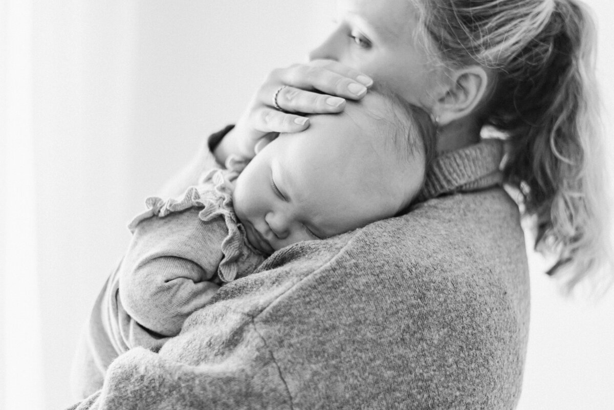 Mother holding baby on her chest in milestone billingshurst photoshoot