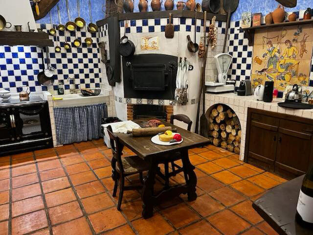 The antique kitchen with a table in the middle inside the winery at Maria Cristina Barrero's Winery Lunch Experience.