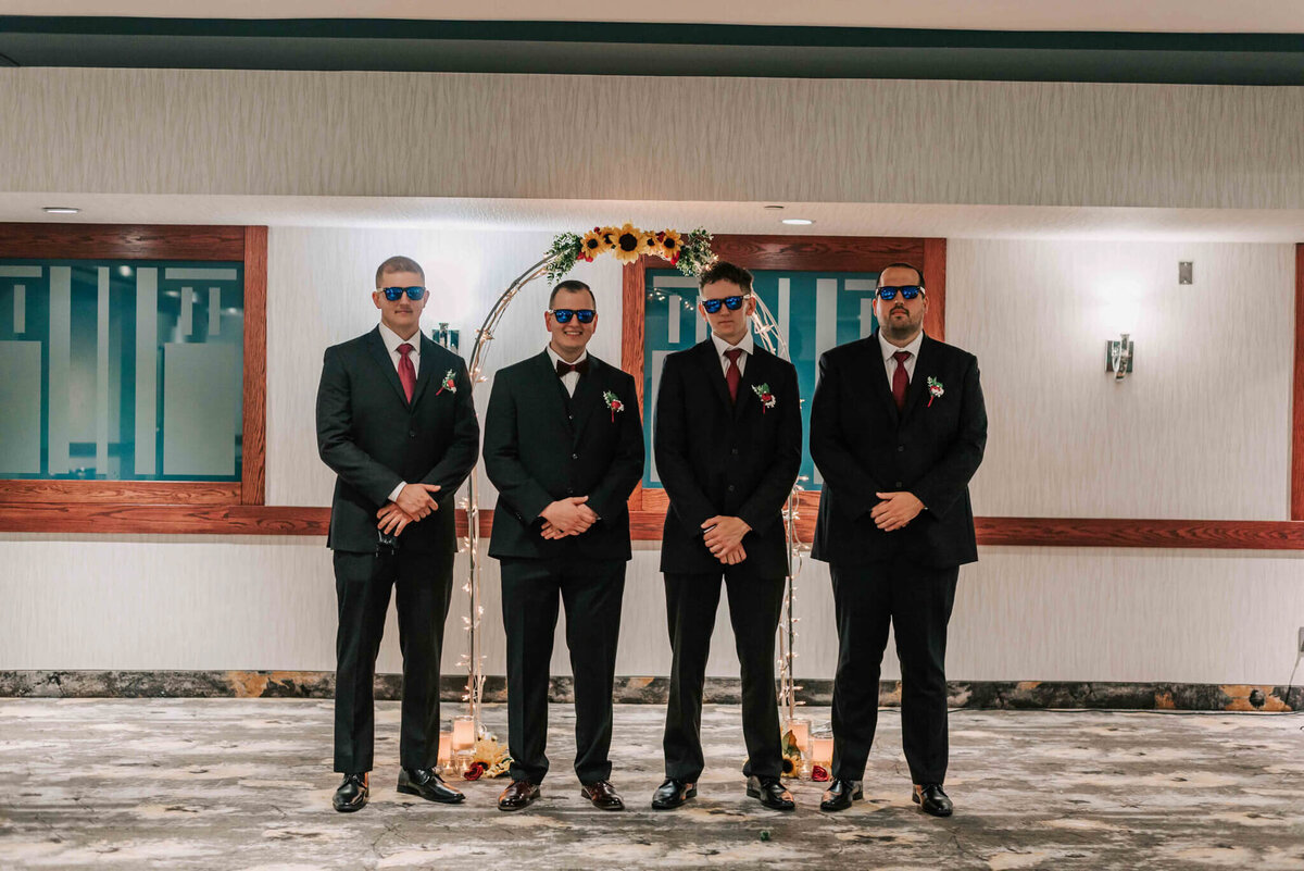 Groom standing with groomsmen .