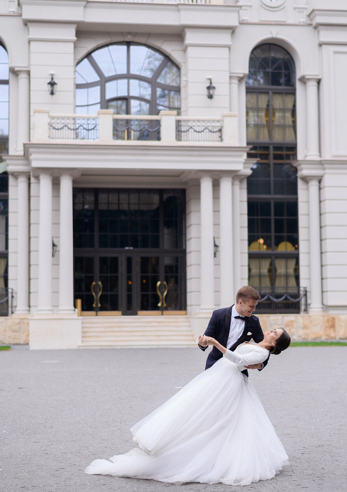 charming-man-woman-having-first-dance-outdoors-near-large-restaurant-loving-bride-couple-enjoying-moment-looking-each-other-cute-bride-groom-having-fun
