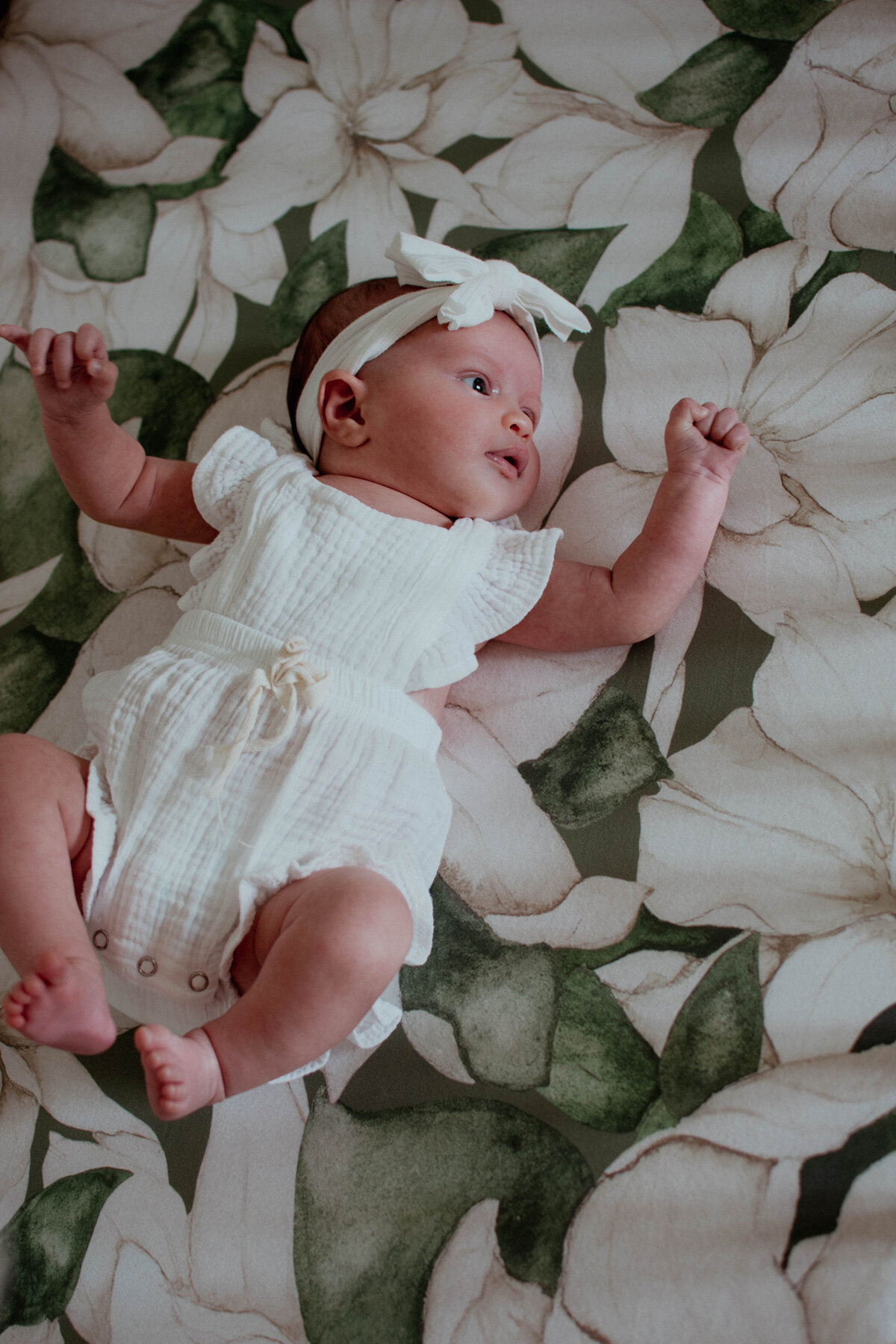 baby girl waking up in her crib during a newborn photoshoot in Chicago, IL