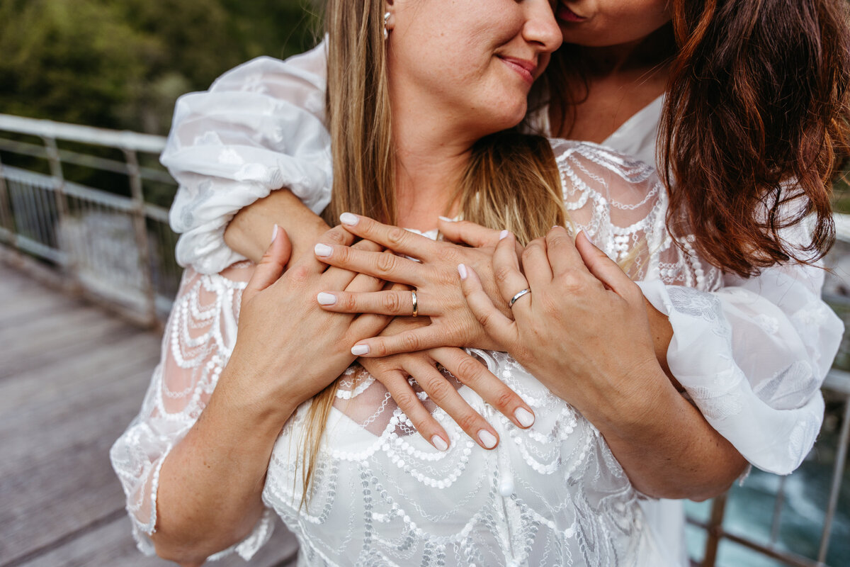 lesbian couples embracing riverside elopement Slovenia