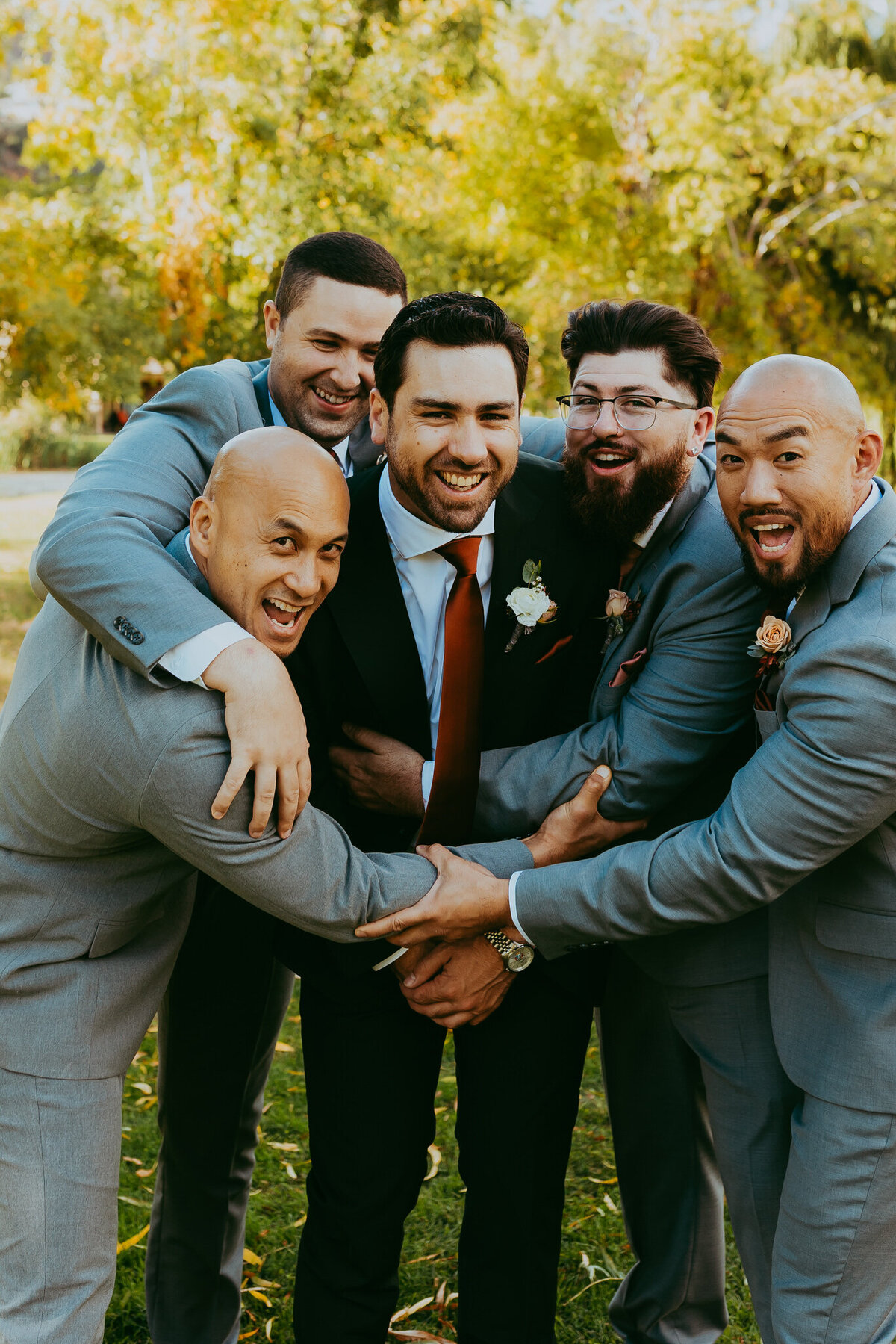 groomsmen stand together laughing