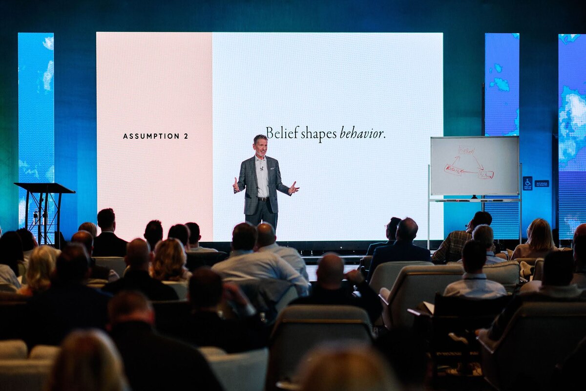 Michael Hyatt on a large stage with bright backlighting and a wide audience view in front