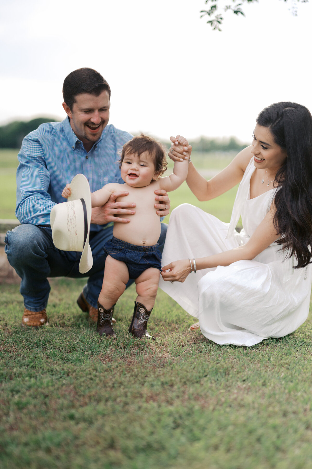 family milestone photos in benbrook, family and toddler smiles while holding cowboy hat