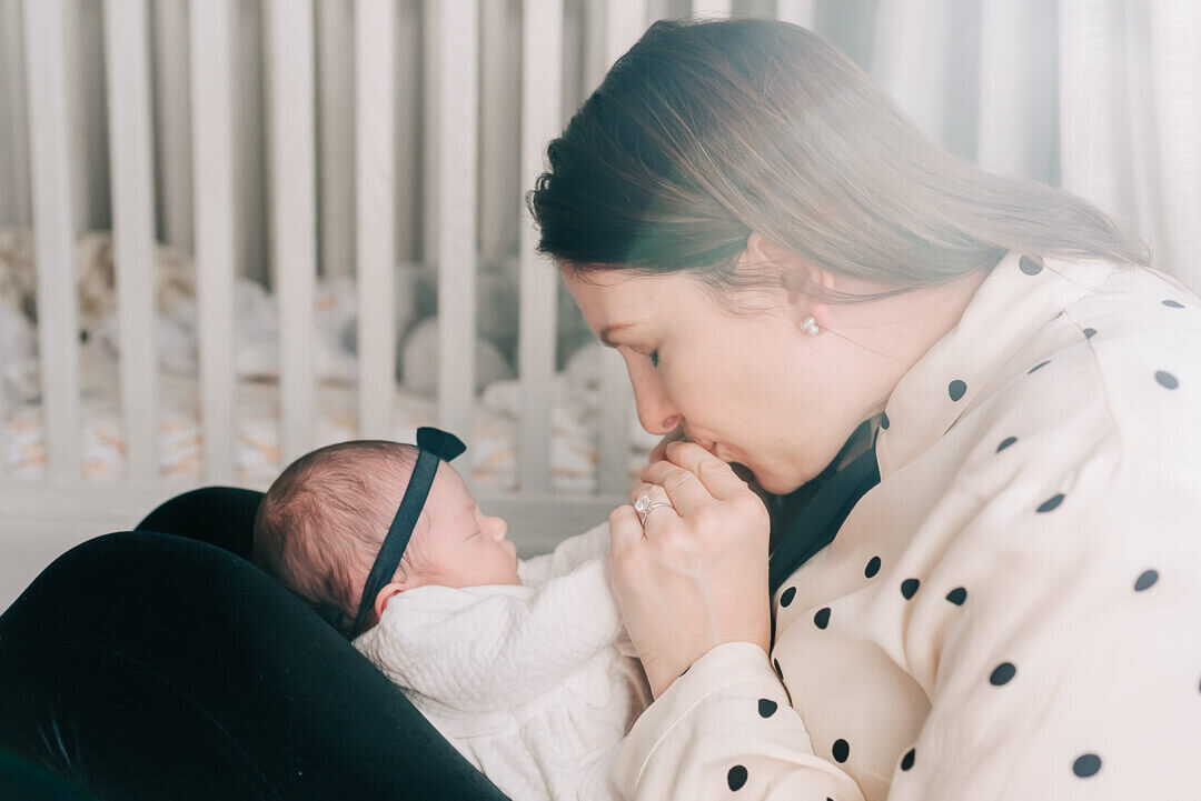 a sweet moment between a mom and her newborn daughter, captured by denise van photography