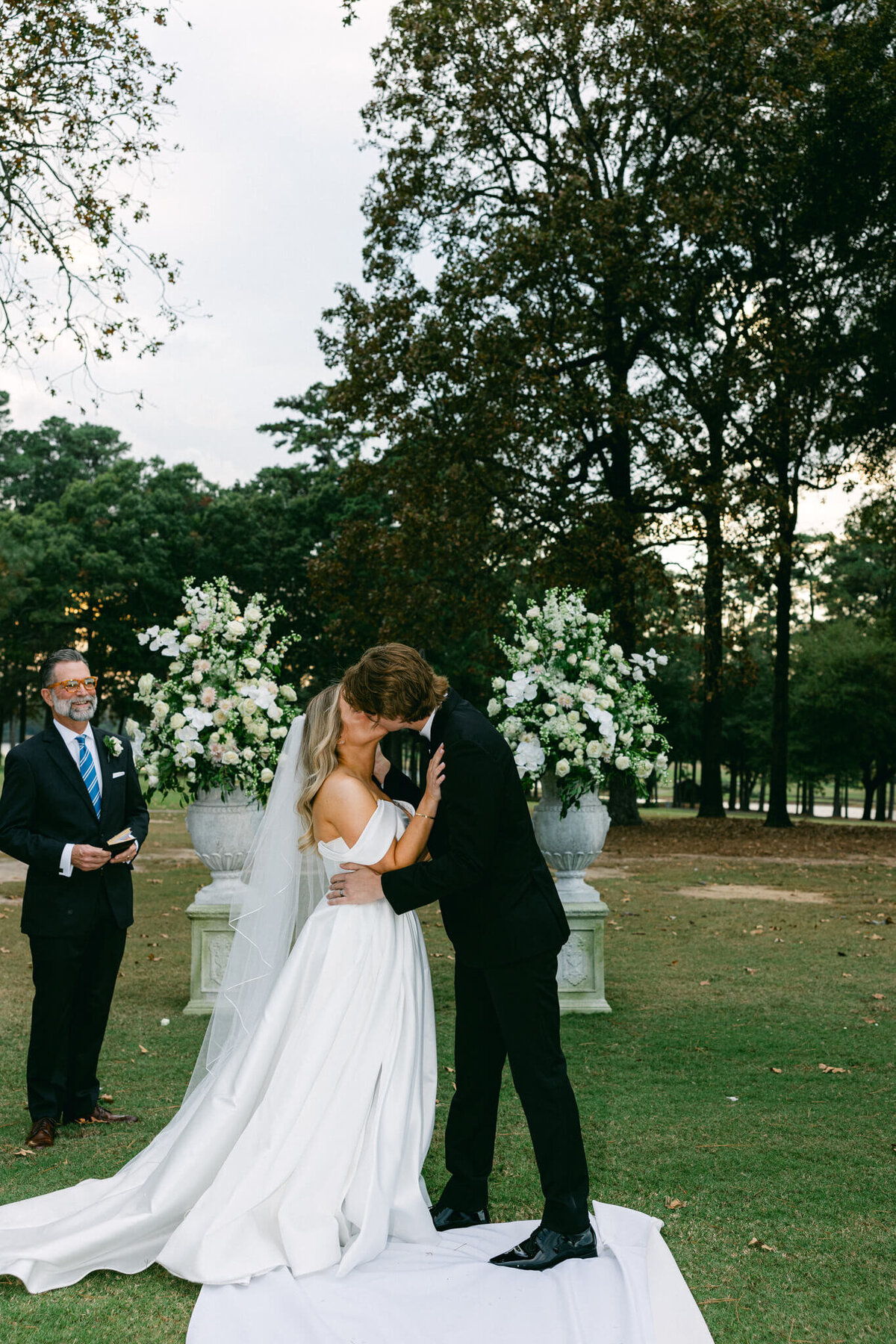 A wedding photo of the bride and groom kissing for the first time