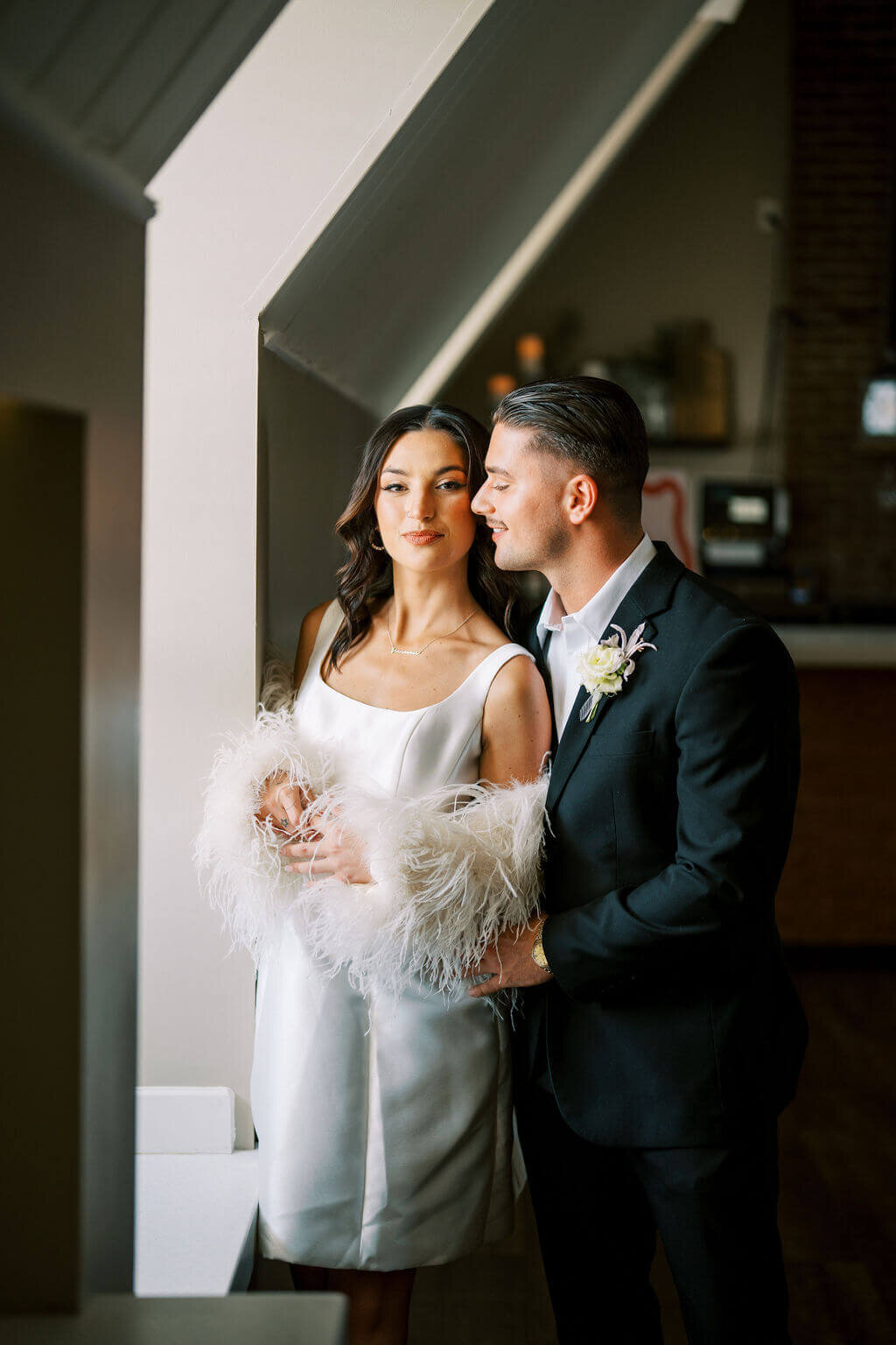 Bride and groom by the window at their wedding reception