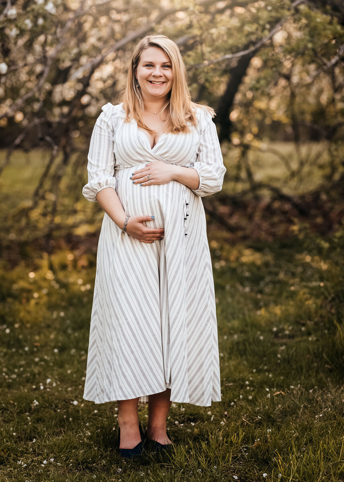 Pregnant mother cradling stomach in maternity portrait by Lisa Smith Photography