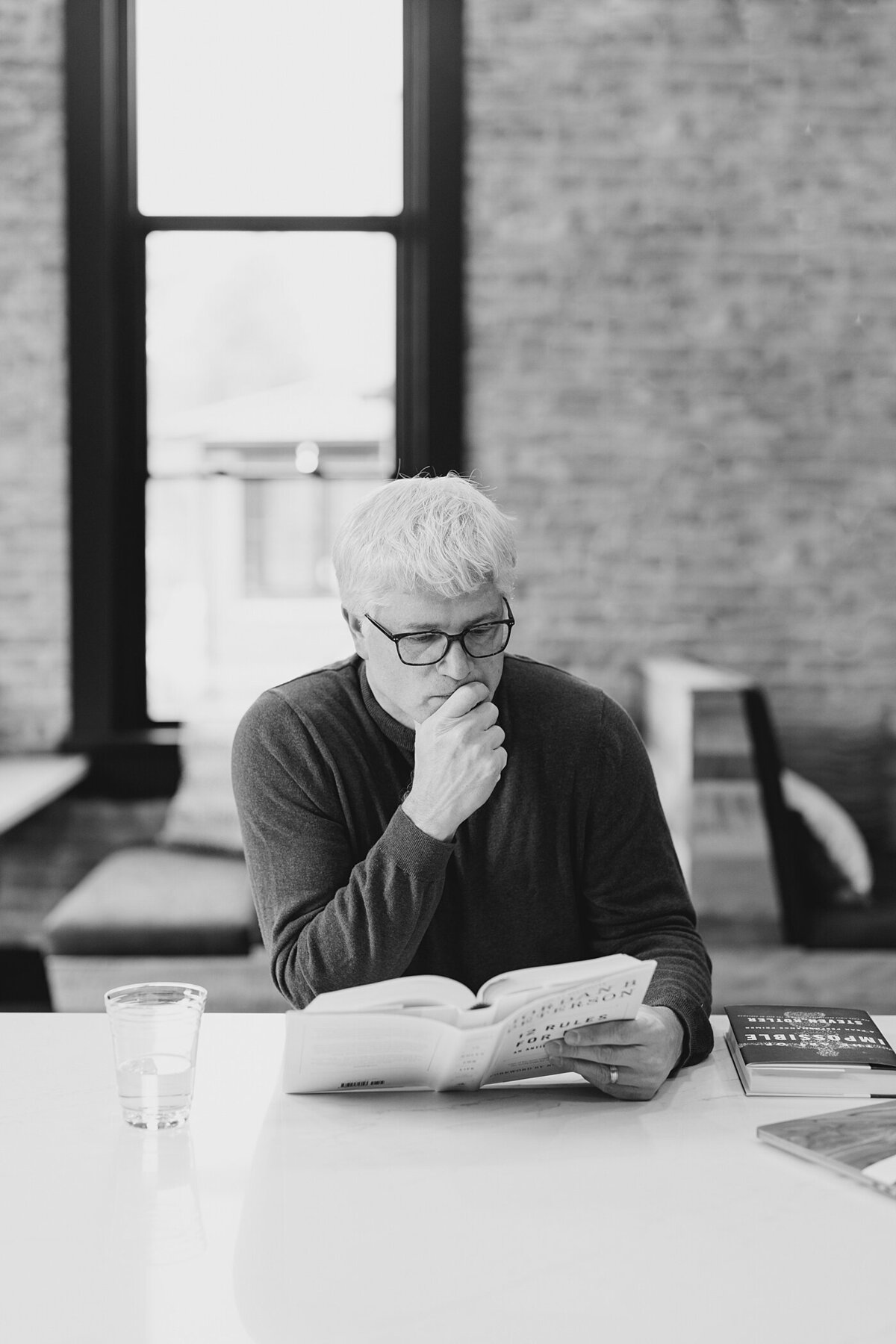 Columbus photographer captures candid moment of man sitting and reading a book in an industrial style lounge