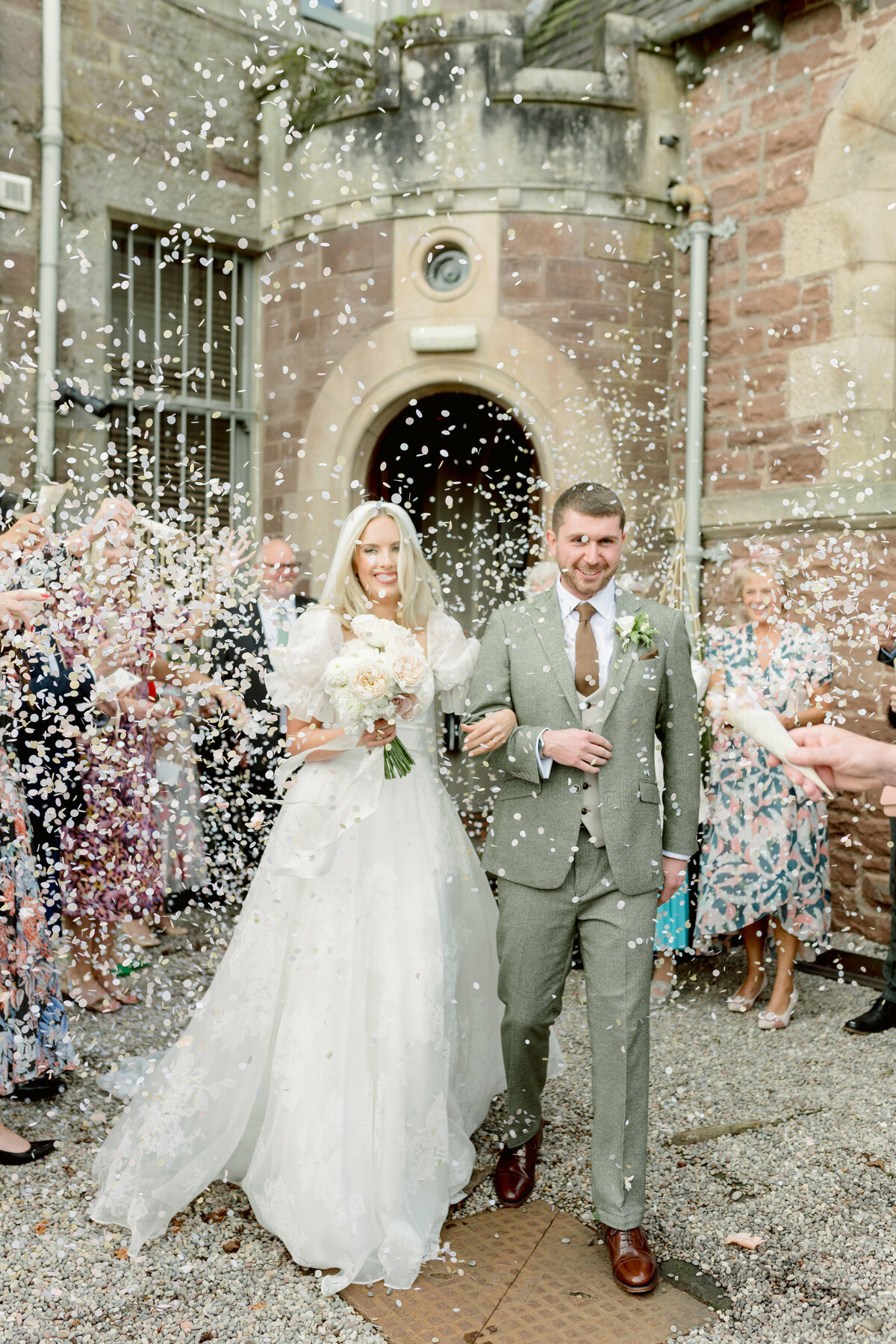 Bride and Groom during their confetti exit from Cromlix House Chapel, Scotland.