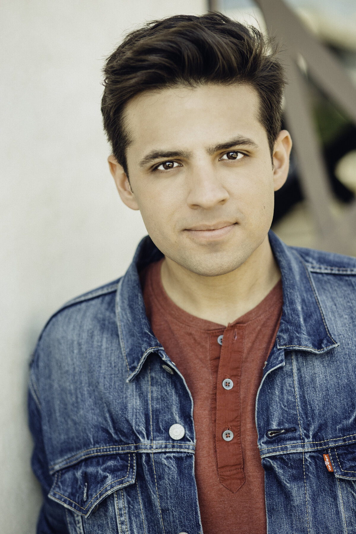 Headshot Photograph Of Young Man In Outer Faded Blue Denim jacket And Inner Red Buttoned Shirt Los Angeles