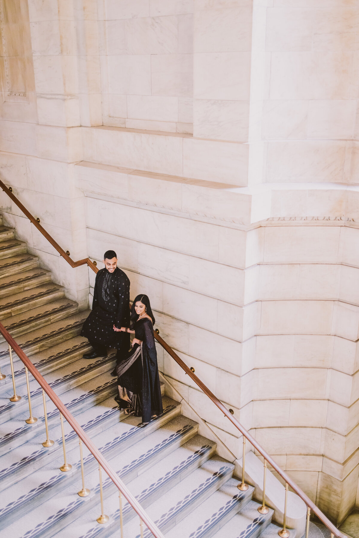 A couple going up the stairs at the new york public library inside 