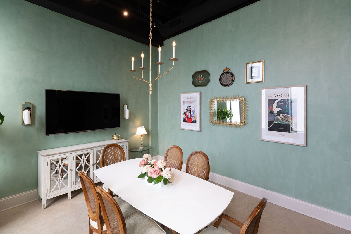 private and relaxing room for clients or vendors, an immediately soothing space featuring a gallery wall and chandelier